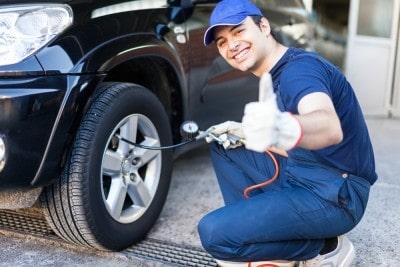 Car mechanic checks the tyres on a vehicle
